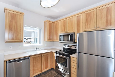 A kitchen with wooden cabinets and stainless steel appliances.